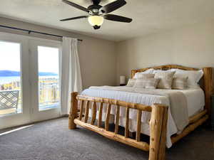 Bedroom featuring carpet flooring, access to outside, a textured ceiling, and ceiling fan