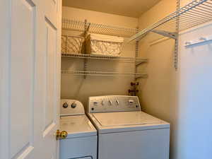 Washroom with a textured ceiling and washing machine and clothes dryer