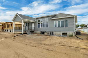 Back of property with a shingled roof and a patio