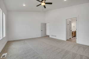 Unfurnished bedroom with light colored carpet, ceiling fan, recessed lighting, and ensuite bath