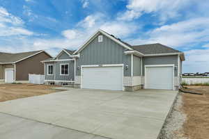 Ranch-style house with board and batten siding, an attached garage, and concrete driveway