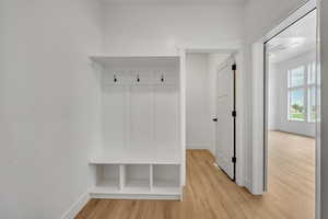 Mudroom with light wood-type flooring and baseboards