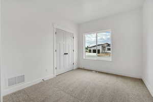 Unfurnished bedroom with carpet and a closet