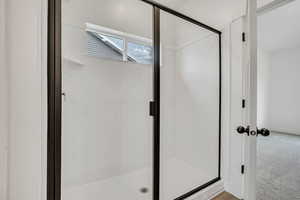 Bathroom featuring a stall shower and baseboards