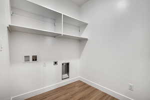 Washroom with hookup for a washing machine, electric dryer hookup, and dark wood-type flooring