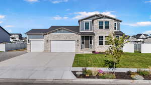 Craftsman house with stone siding, an attached 3 car garage, and concrete driveway