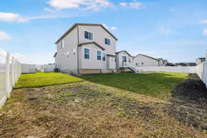 Back of property with a fenced backyard and stucco siding