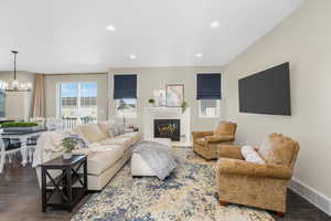 Living area featuring dark wood-type flooring, recessed lighting, and a glass covered fireplace
