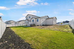 Back of house with a fenced backyard, a residential view, and stucco siding
