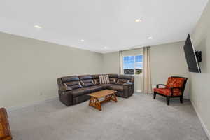 Carpeted loft with recessed lighting