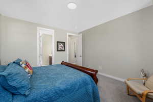 Primary Bedroom featuring carpet flooring and en suite bathroom