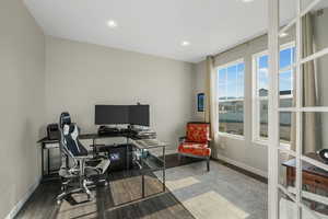 Office with wood finished floors and recessed lighting