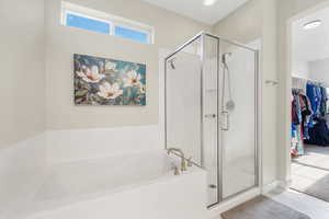 Primary Bedroom en suite Bathroom with a stall shower, a bath, and a walk in closet