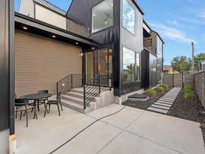 Rear view of property featuring a patio, a gate, outdoor dining area, and a standing seam roof