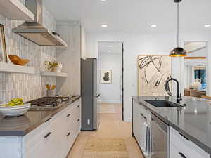 Kitchen with modern cabinets, wall chimney exhaust hood, pendant lighting, backsplash, and recessed lighting