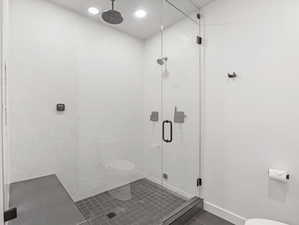 Bathroom with a shower stall and dark tile patterned floors