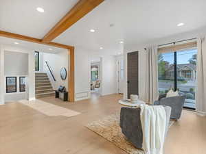 Entry way with recessed lighting, light wood finished floors, beamed ceiling, and stairway