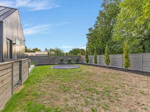 Fenced backyard with a trampoline
