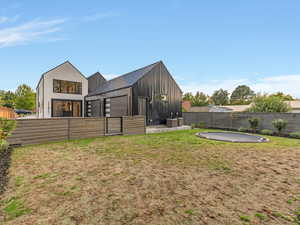 Back of property with a standing seam roof, a fenced backyard, a metal roof, and board and batten siding