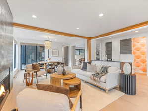 Great room with a fireplace, recessed lighting, a chandelier, light wood-type flooring, and beamed ceiling