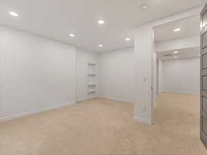 Basement featuring recessed lighting and light colored carpet