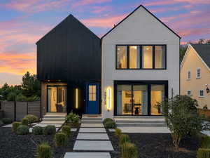Front of house at dusk featuring stucco siding and board and batten siding