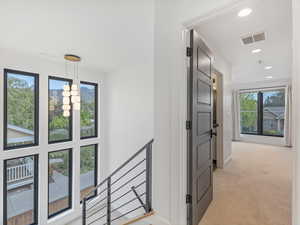Hall featuring light carpet, recessed lighting, and a chandelier