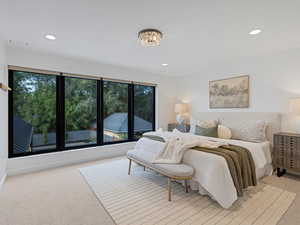 Bedroom with light colored carpet, recessed lighting, and a chandelier