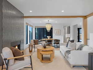 Great room with a chandelier, a lit fireplace, and recessed lighting