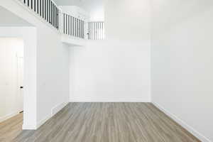 Unfurnished room with light wood finished floors and a high ceiling