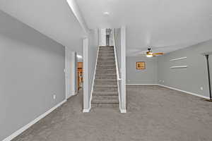 Staircase featuring carpet flooring, a textured ceiling, and a ceiling fan