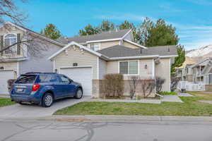 Traditional home with a shingled roof, driveway, and an attached garage