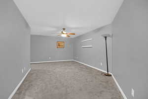 Unfurnished room featuring light carpet and a ceiling fan