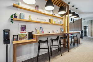 Bar area with elevator, open shelves, wood counters, and pendant lighting