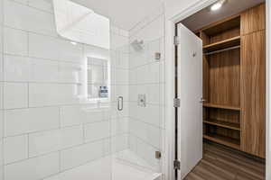 Bathroom with a stall shower and dark wood-style floors