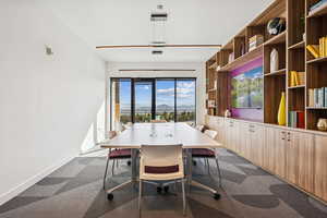 Dining space featuring dark carpet and baseboards