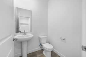 Bathroom featuring dark wood-style flooring and toilet