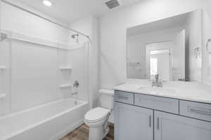 Bathroom featuring shower / bath combination, vanity, and light wood-style floors