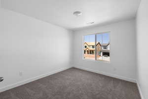 Carpeted empty room featuring baseboards and a textured ceiling