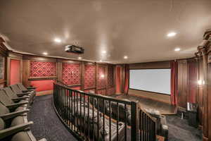 Home theater room with dark colored carpet and recessed lighting