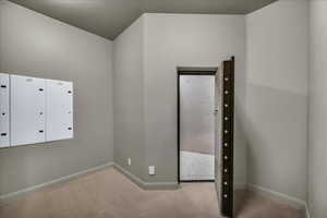 Unfurnished bedroom with carpet flooring and baseboards