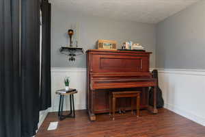 Sitting room with a textured ceiling and dark wood finished floors