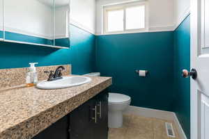 Half bath with vanity and light tile patterned floors