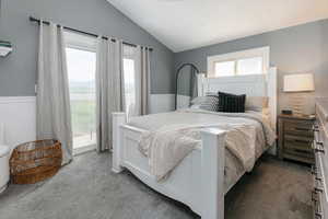 Carpeted bedroom with access to outside and lofted ceiling