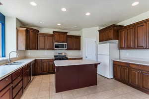 Kitchen featuring recessed lighting, appliances with stainless steel finishes, light countertops, light tile patterned flooring, and a textured ceiling