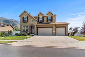 Traditional-style house featuring stucco siding, concrete driveway, an attached garage, and a mountain view