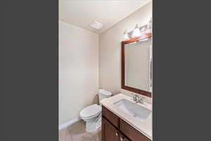 Bathroom featuring a textured ceiling, vanity, and light tile patterned flooring