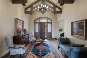 Entrance foyer featuring high vaulted ceiling, beamed ceiling, and a chandelier