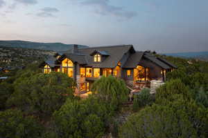 View of front of property with a chimney, stone siding, and a shingled roof