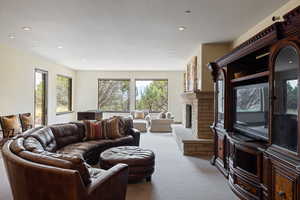 Living area featuring carpet floors, a fireplace, and recessed lighting